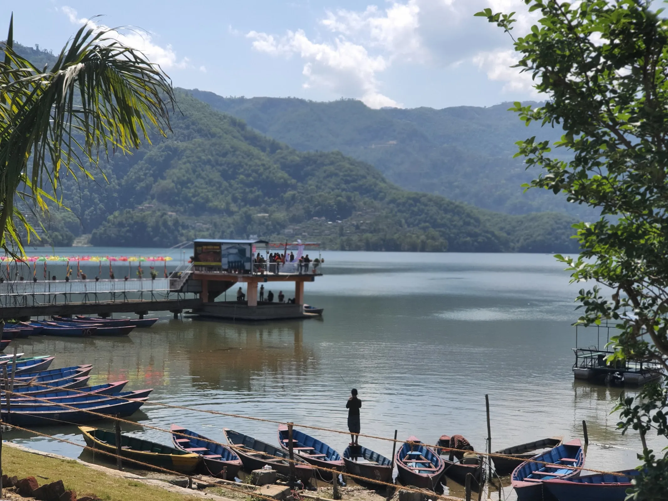 Phewa Lake jetty at midday with painted wooden boats